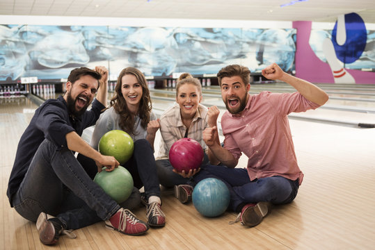 Two couples spending time in bowling club