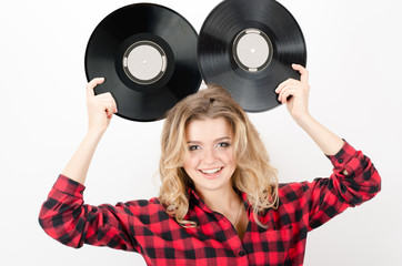 Funny cheerful curly young woman posing with vinyl records isolated over white background