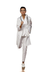 beautiful woman doctor in uniform running with clipboard in her hand