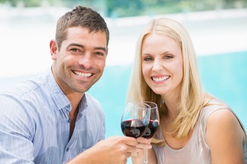 Portrait of smiling couple toasting red wine