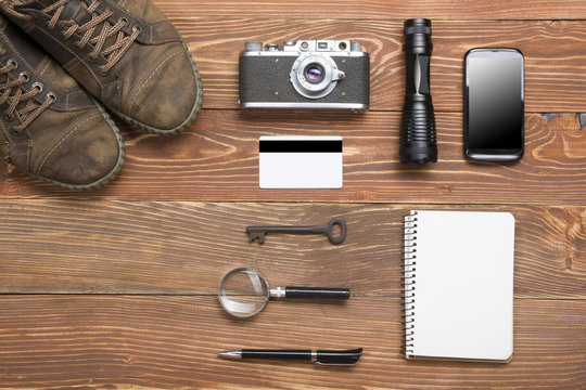 Travel, vacation concept. Camera, notepad, pen, credit card, supplies and photography on office wooden desk table. Top view with copy space for text