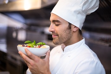 Handsome chef smelling pasta