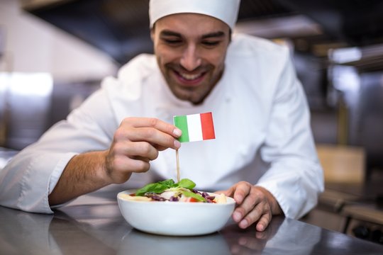 Handsome chef presenting meal with italian flag