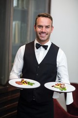 Portrait of waiter presenting meals