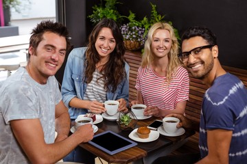 Smiling friends enjoying coffee together