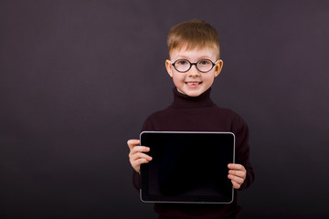 cute smiling boy of five years with a tablet in hands