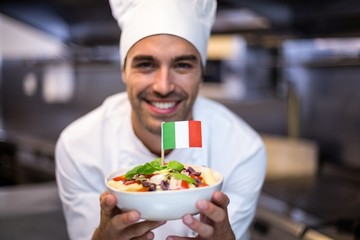 Handsome chef presenting meal with italian flag - obrazy, fototapety, plakaty