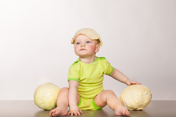 Fototapeta premium child with cabbage on a white background in studio