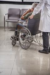 Obraz premium Doctor consulting with a patient in a wheelchair