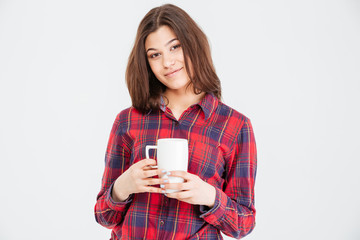 Smiling attractive young woman in checkered shirt with white cup
