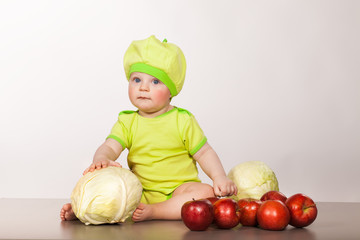 Fototapeta premium child with cabbage and apples on a white background in studio
