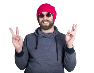 Handsome young bearded hipster in pink knitted hat expresses various emotions and shows different signs the fingers. isolated on white background