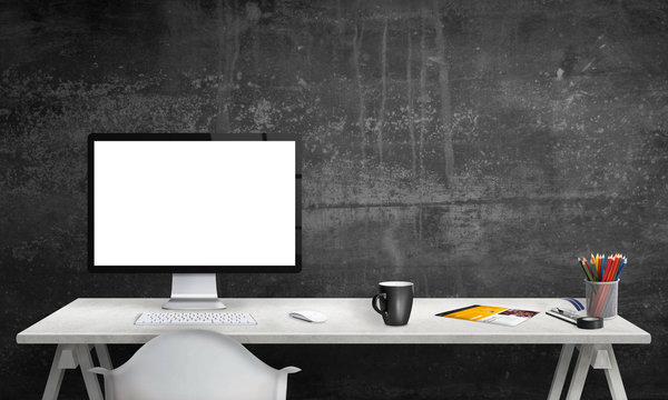 Isolated computer display for mockup in office interior. Work desk with keyboard, mouse, cup of coffee, paper, pencils. Free space on wall for text.