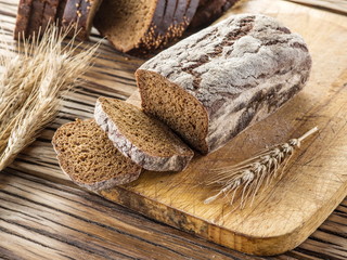 Sliced black bread on the wooden plank.