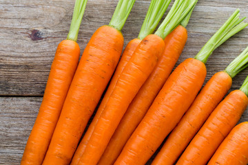 Fresh carrots bunch on rustic wooden background.