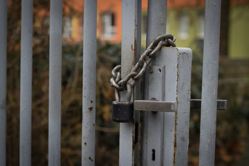 Padlock with iron chain on the old gray fence; locked location