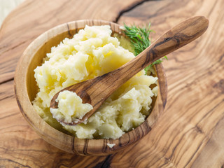 Mashed potatoes in the wooden bowl on the service tray.