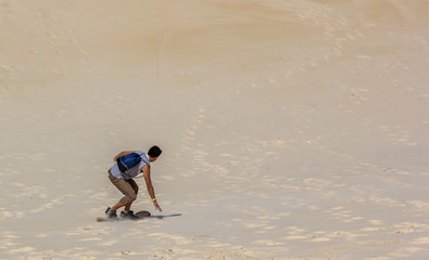 Praticando sandboard na duna.