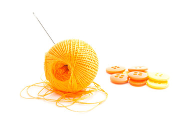 spool of thread and orange buttons