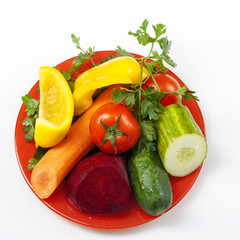 bright vegetables on a plate top view on a white background