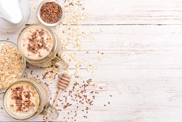 Schapenvacht deken met patroon Milkshake Smoothies with oatmeal, flax seeds in glass jars on a wooden background.