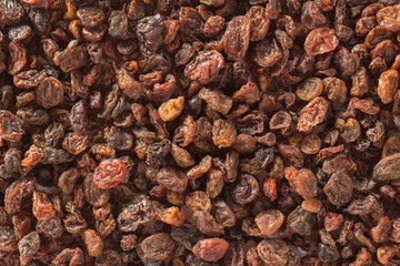 Macro background with a pile of raisins and wooden spoon
