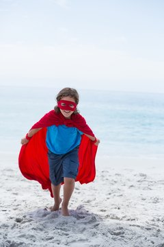 Boy In Superhero Costume Running While Holding Cape