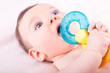 Baby girl with rattle teether toy.