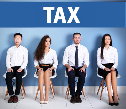 Tax concept. Young people sitting on a chairs in blue hall