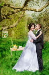 Young bride and groom in the park. Groom and bride in a white dress in the spring garden
