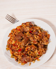 Rice with meat and vegetables on plate