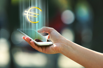Hand holding a mobile phone with euro sign outdoors, on blurred background - obrazy, fototapety, plakaty