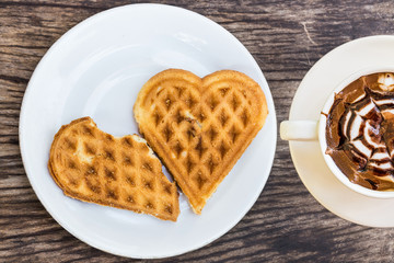 waffles heart shaped on white plate and coffee cup for breakfast 