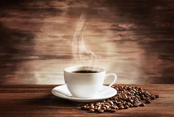 Tuinposter Koffiebar Cup of coffee with grains on wooden background