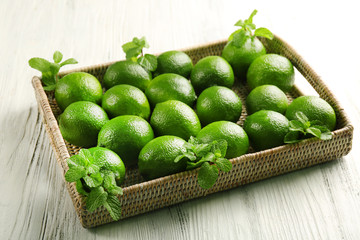 Wicker basket of limes on table
