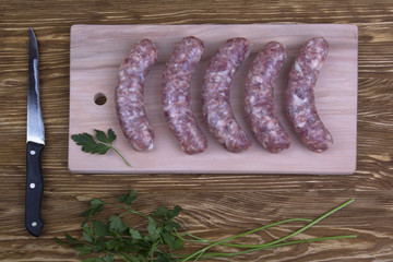 Raw sausages on wooden table