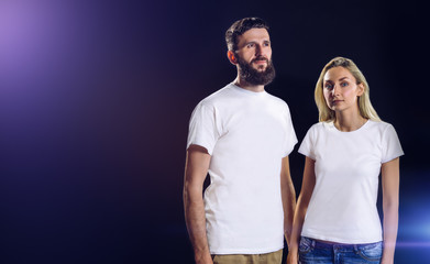 Man and woman in white t-shirts on a dark background with the lens flare.