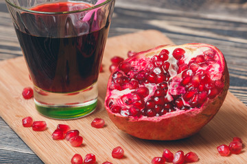 Ripe pomegranates with juice on table close-up