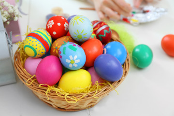 Fototapeta na wymiar Colorful Easter eggs in wicker nest closeup