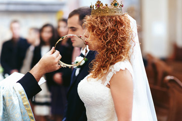 stylish luxury red haired bride and elegant groom, with crowns,