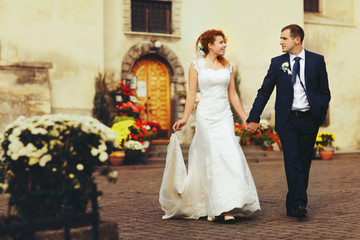 Fototapeta premium stylish luxury red haired bride and elegant groom, walking with