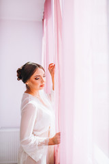 Obraz na płótnie Canvas bride in the morning. Bride in a bathrobe with a happy face waiting for a wedding dress. Bride posing