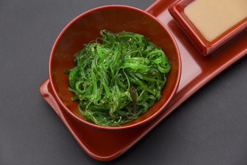 Chuka salad with nut sauce over black background