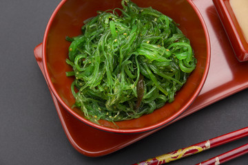 Chuka salad with nut sauce over black background