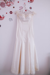 The perfect wedding dress with a full skirt on a hanger in the room