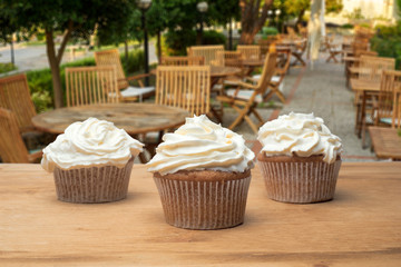 Three cupcakes on a wooden table