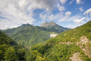 White clouds in the blue sky over the mounts.