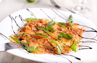 Salmon carpaccio on white plate