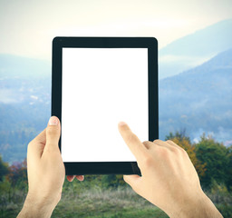 Hands holding tablet-pc with empty screen, on nature background