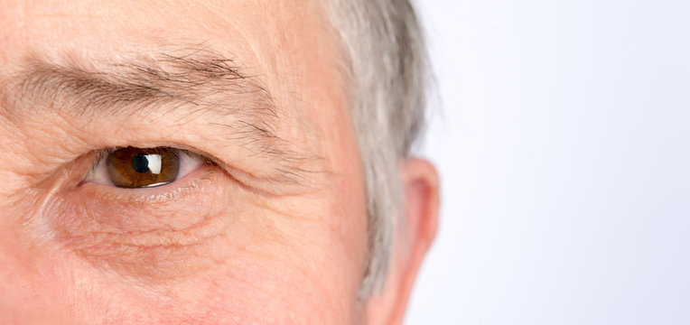 Close-up view on the eye of senior man. Horizontal photo
